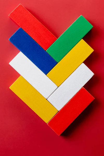 Vue de dessus de blocs rectangulaires multicolores lumineux sur fond rouge — Photo de stock