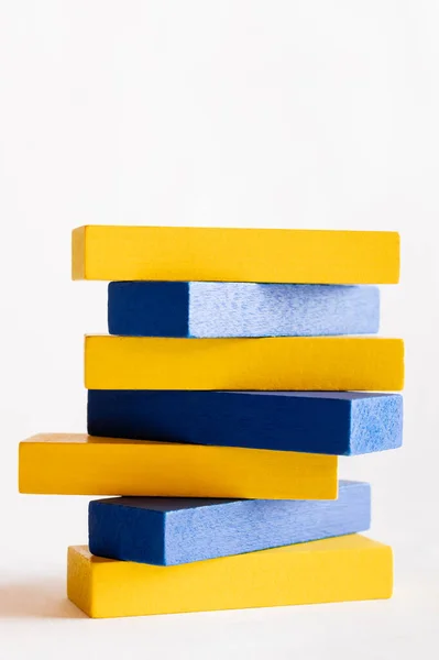 Pila de bloques azules y amarillos sobre fondo blanco, concepto ucraniano - foto de stock