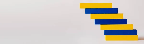 Bloques de color azul y amarillo apilados sobre fondo blanco, concepto ucraniano, bandera - foto de stock