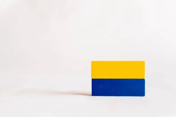 Bloques rectangulares azules y amarillos sobre fondo blanco con espacio de copia, concepto ucraniano - foto de stock