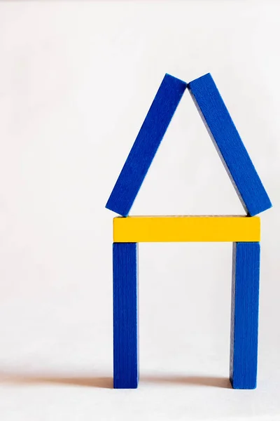 Símbolo de la casa hecha de bloques azules y amarillos sobre fondo blanco, concepto ucraniano - foto de stock