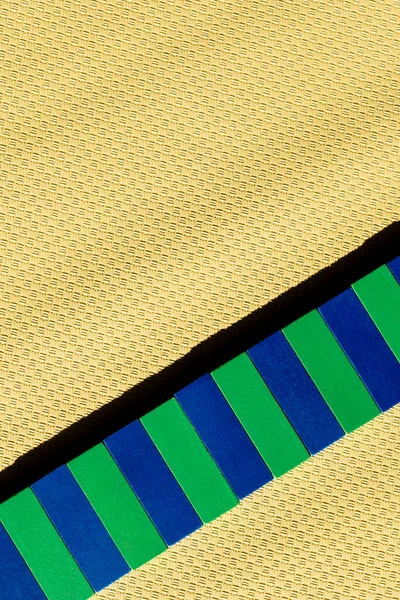 Vista superior de la línea de bloques azules y verdes en la superficie texturizada beige con espacio de copia - foto de stock