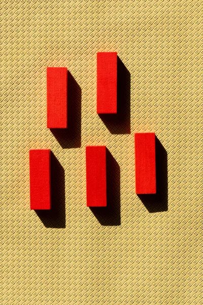 Vista superior de blocos vermelhos brilhantes no fundo texturizado bege com sombras — Fotografia de Stock