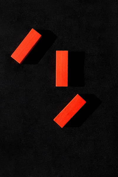 Draufsicht auf drei rote Blöcke auf schwarzem Hintergrund — Stockfoto