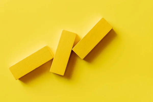 Vue de dessus de trois blocs colorés sur fond jaune — Photo de stock