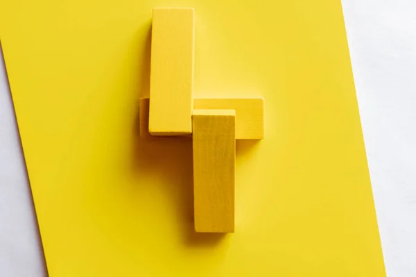 Vista superior de quatro blocos tetragonais sobre fundo amarelo — Fotografia de Stock