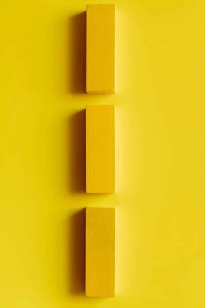 Vista superior de bloques de colores en línea vertical sobre fondo amarillo - foto de stock