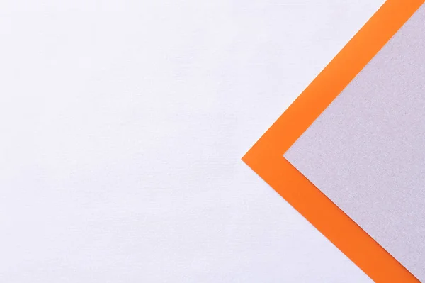 Papel violeta y naranja sobre fondo lavanda claro - foto de stock