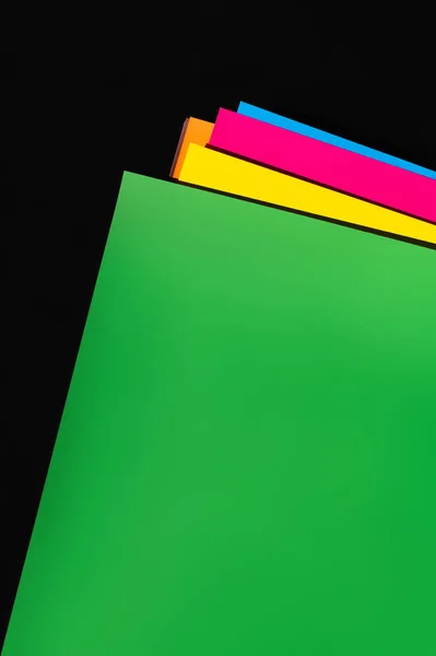 Bright multicolored paper sheets on black background — Stock Photo