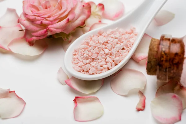 Vista de perto da flor perto de pétalas e sal do mar rosa no branco — Fotografia de Stock