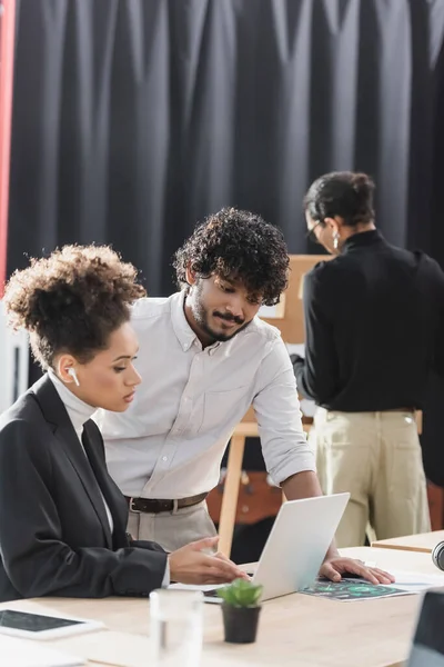 Multiethnische Geschäftsleute nutzen Laptop in der Nähe von Dokumenten im Büro — Stockfoto