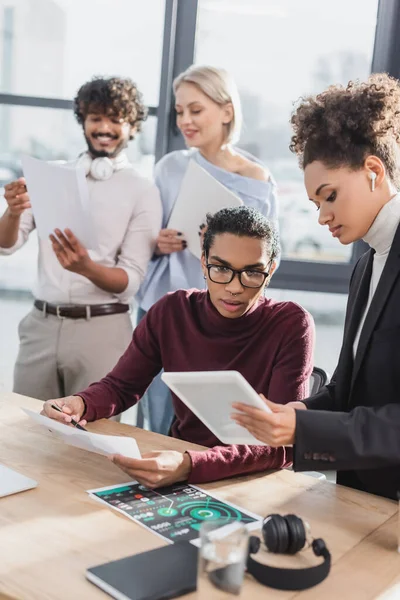 Uomini d'affari afroamericani che lavorano con tablet digitale e carta in ufficio — Foto stock