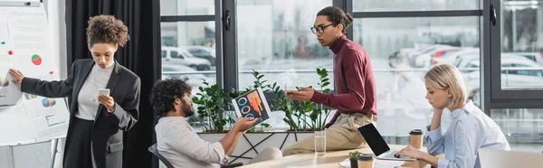 Imprenditori multiculturali che lavorano con documenti e laptop in ufficio, banner — Foto stock