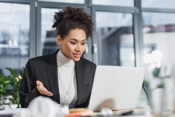 Sorrindo afro-americana empresária ter chamada de vídeo no laptop no escritório — Fotografia de Stock