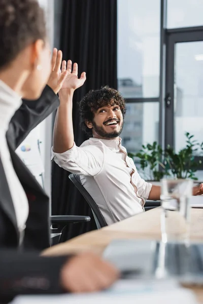 Positive indian businessman giving high five to african american colleague in office — Stock Photo