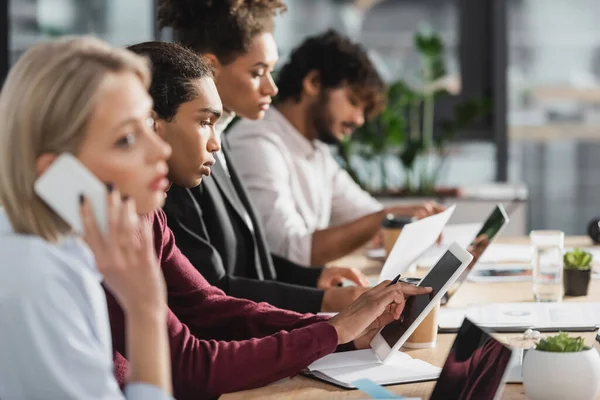 Afrikanischer Geschäftsmann nutzt digitales Tablet in der Nähe multiethnischer Kollegen im Büro — Stockfoto