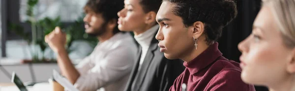 Side view of african american businessman looking away near multiethnic colleagues, banner — Stock Photo