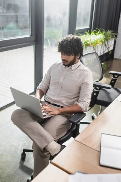 Jovem empresário indiano usando laptop no escritório — Fotografia de Stock