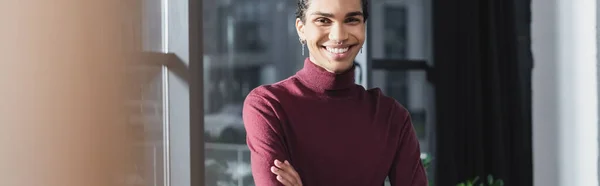 Alegre hombre de negocios afroamericano mirando la cámara en la oficina, pancarta - foto de stock