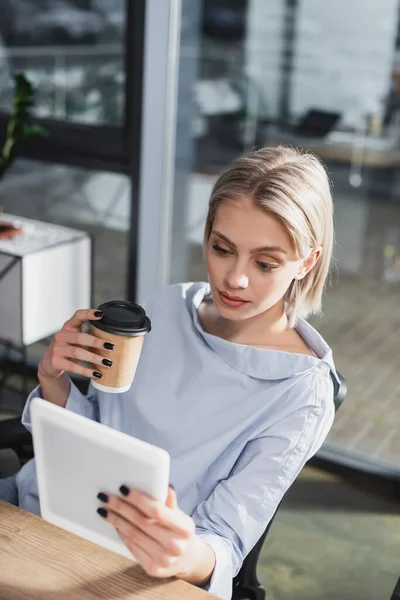 Joven empresario sosteniendo tableta digital y café para ir en la oficina - foto de stock