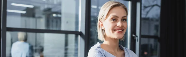 Positive Geschäftsfrau blickt im Büro in die Kamera, Banner — Stockfoto