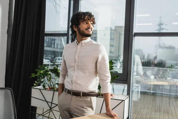 Sorridente uomo d'affari indiano in piedi in ufficio — Foto stock