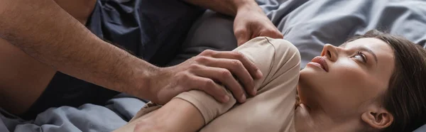 Shirtless man touching brunette girlfriend on bed, banner — Stock Photo