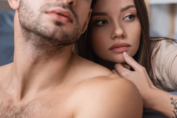 Pretty woman touching chin near shirtless boyfriend at home — Stock Photo