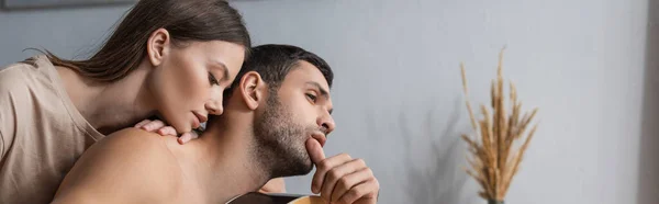 Young woman touching shirtless boyfriend at home, banner — Stock Photo