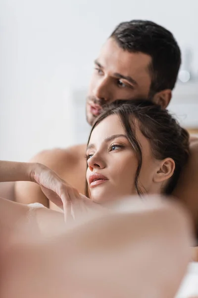 Brunette woman lying in bath with blurred boyfriend at home — Stock Photo