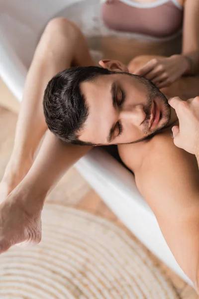 Vue du dessus de la femme floue touchant petit ami barbu dans la baignoire — Photo de stock