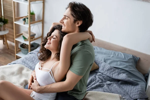 Vue grand angle de jeune femme heureuse étreignant petit ami dans la chambre — Photo de stock