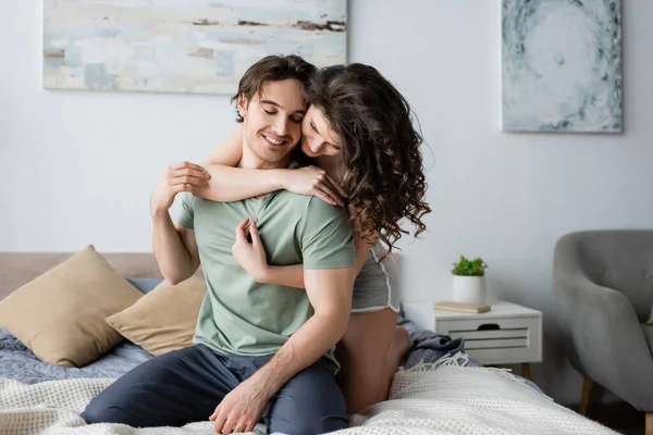 Curly woman hugging happy boyfriend with closed eyes — Stock Photo
