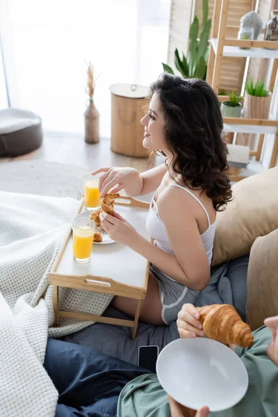 High angle view of happy woman having breakfast in bed with boyfriend — Stock Photo