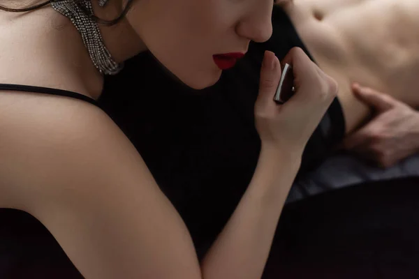 Abgeschnittene Ansicht einer sexy Frau mit roten Lippen, die den Gürtel ihres Freundes zieht — Stockfoto