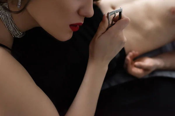 Cropped view of woman with red lips pulling belt of boyfriend — Stock Photo