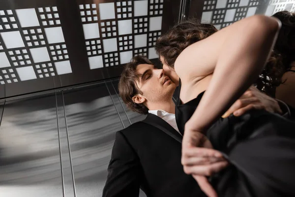 Vista de ángulo bajo de pareja sexy en ascensor - foto de stock