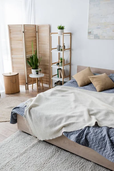 Green plants and folding screen in modern bedroom — Stock Photo