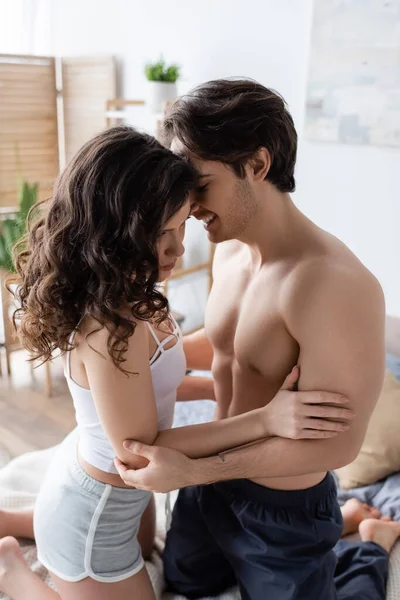 Happy shirtless man hugging curly woman in morning — Stock Photo