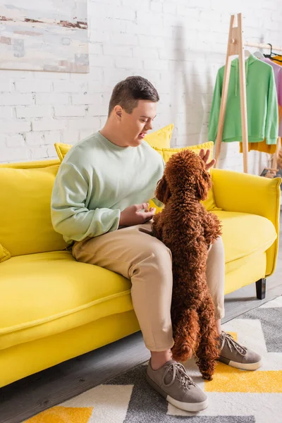 Adolescente com síndrome de down brincando com poodle em casa — Fotografia de Stock