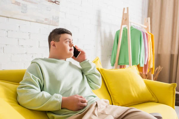 Adolescent garçon avec vers le bas syndrome parler sur téléphone mobile à la maison — Photo de stock