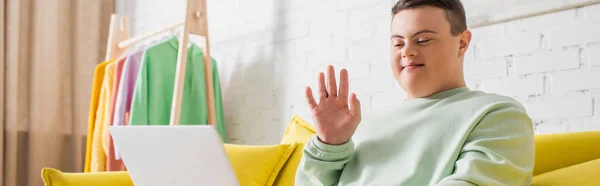 Teenager with down syndrome having video chat on laptop at home, banner — Stock Photo