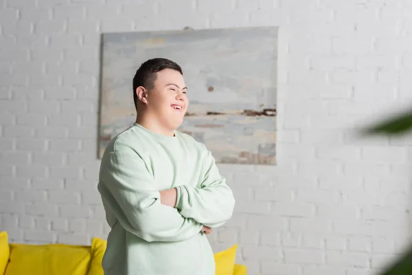 Cheerful teenager with down syndrome standing at home — Stock Photo