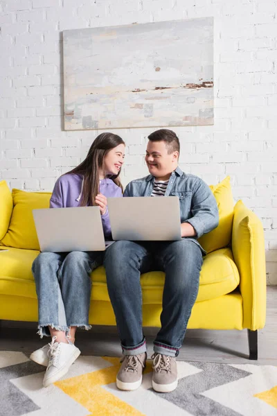 Fröhliche Teenager mit Down-Syndrom sprechen zu Hause mit Laptops — Stockfoto