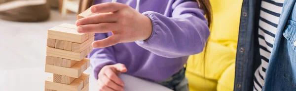 Vista ritagliata di adolescente giocare blocchi di legno gioco vicino amico a casa, banner — Foto stock