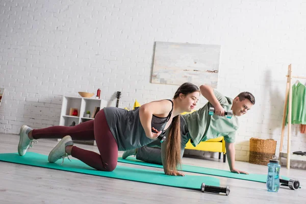 Teenagers with down syndrome training with dumbbells at home — Stock Photo