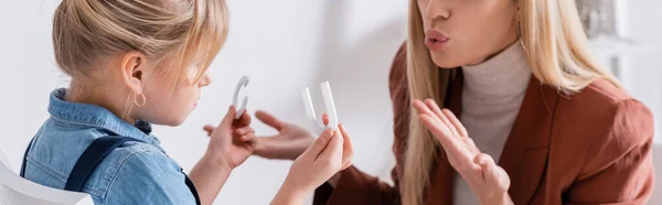 Speech therapist parlando vicino bambino con lettere in sala di consultazione, banner — Foto stock