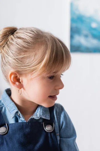 Niño preescolar con camisa vaquera mirando hacia otro lado en el aula — Stock Photo