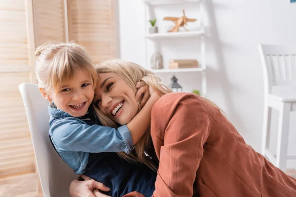 Ragazzo positivo che abbraccia logopedista in classe — Foto stock