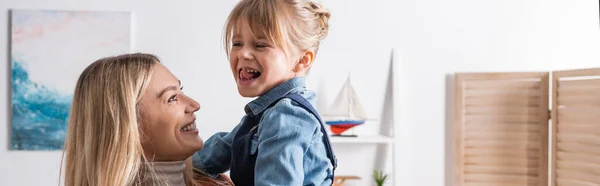 Smiling speech therapist looking at girl in classroom, banner — Stock Photo